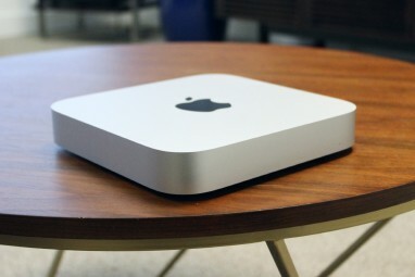 Der Mac mini auf einem Holzschreibtisch.